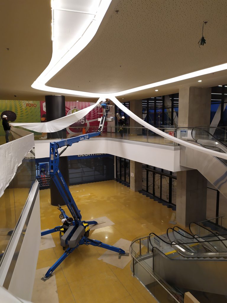 Instalación de membrana tensada curva iluminada en centro comercial